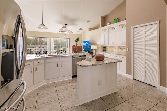 5471 Harborage Dr, Fort Myers, FL 33908 - kitchen with light tile patterned floors, a sink, stainless steel appliances, vaulted ceiling, and white cabinets