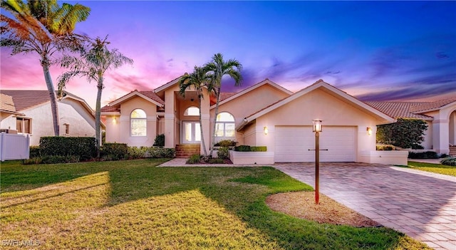 5471 Harborage Dr, Fort Myers, FL 33908 - mediterranean / spanish house featuring stucco siding, an attached garage, decorative driveway, and a front yard