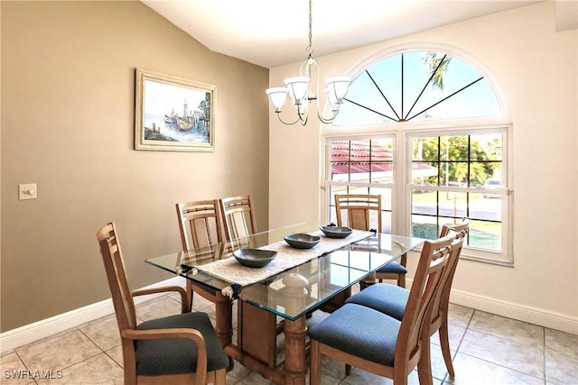 dining area with light tile patterned floors, baseboards, and a notable chandelier