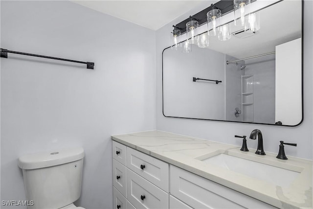 bathroom featuring vanity, toilet, and a shower