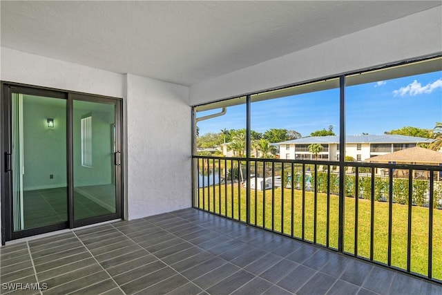 unfurnished sunroom featuring a water view