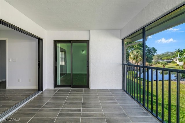 unfurnished sunroom featuring a water view