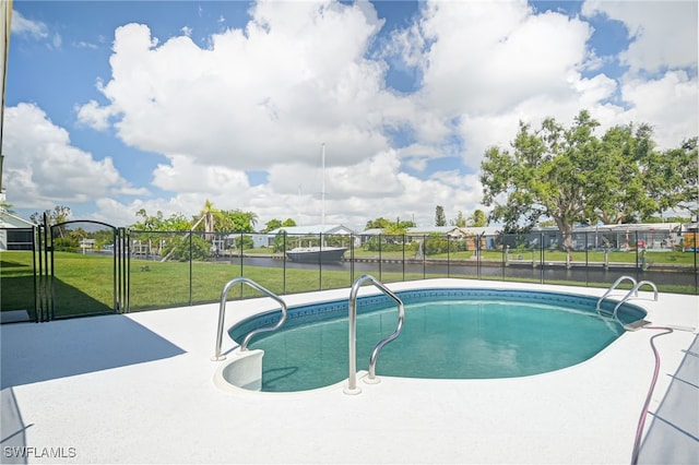 view of pool with a patio area and a lawn