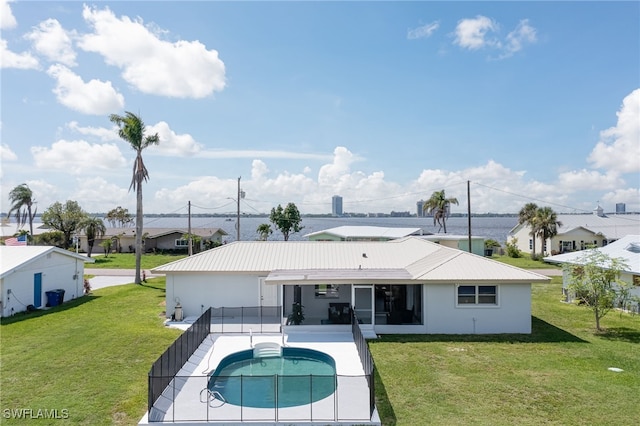 back of property with a lawn, a patio area, and a fenced in pool