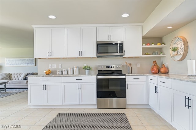 kitchen featuring white cabinets, light tile patterned floors, and stainless steel appliances