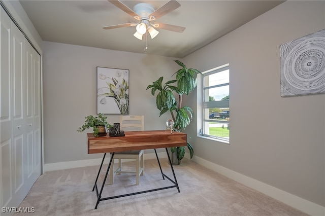 carpeted office space featuring ceiling fan