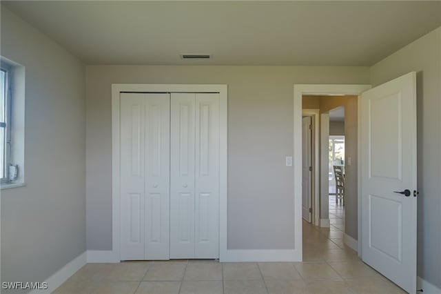 unfurnished bedroom featuring light tile patterned floors and a closet