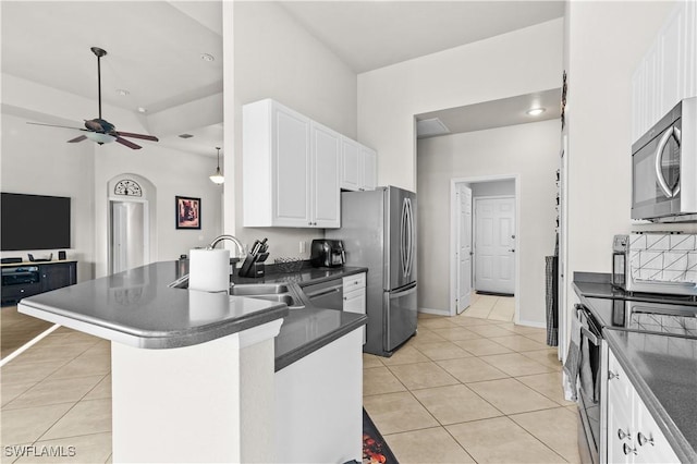 kitchen with kitchen peninsula, stainless steel appliances, sink, white cabinets, and light tile patterned flooring