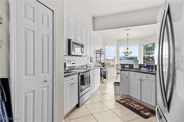 kitchen featuring a chandelier, appliances with stainless steel finishes, white cabinetry, and hanging light fixtures