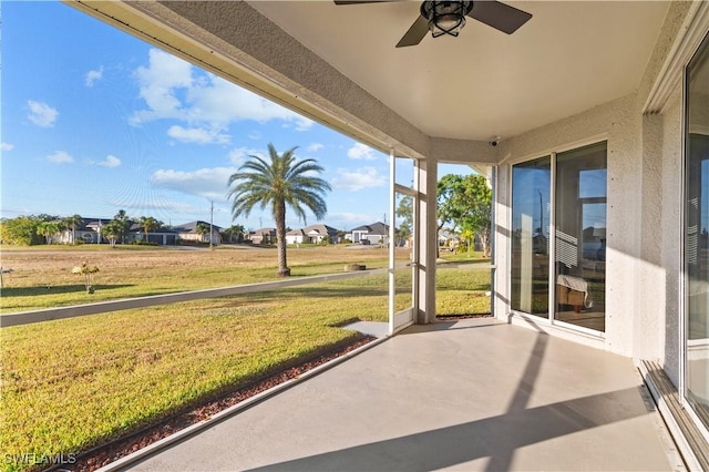 unfurnished sunroom featuring ceiling fan