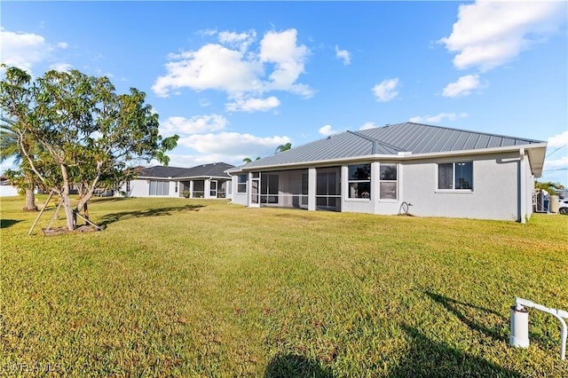 back of house with a sunroom and a yard