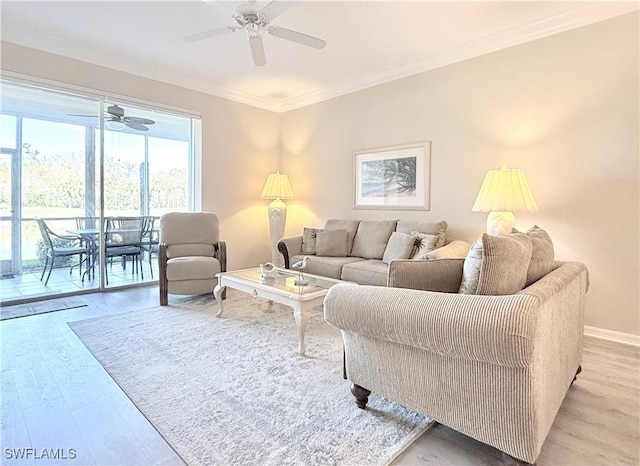 living room featuring ceiling fan, ornamental molding, and light hardwood / wood-style flooring