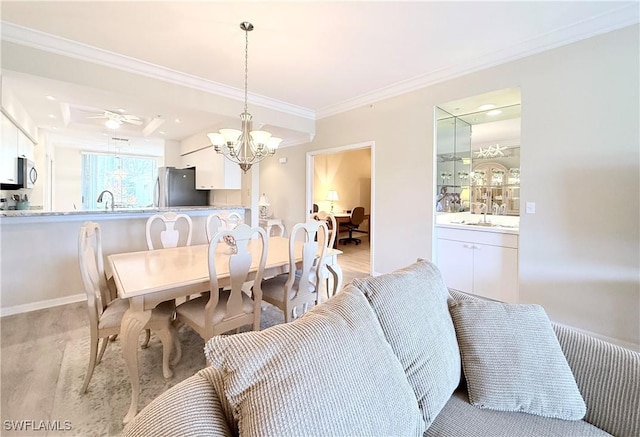 dining area featuring ceiling fan with notable chandelier, ornamental molding, and sink