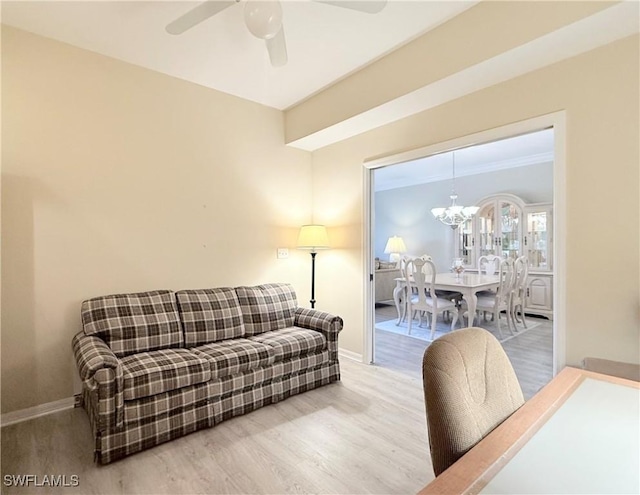 living room with hardwood / wood-style floors and ceiling fan with notable chandelier