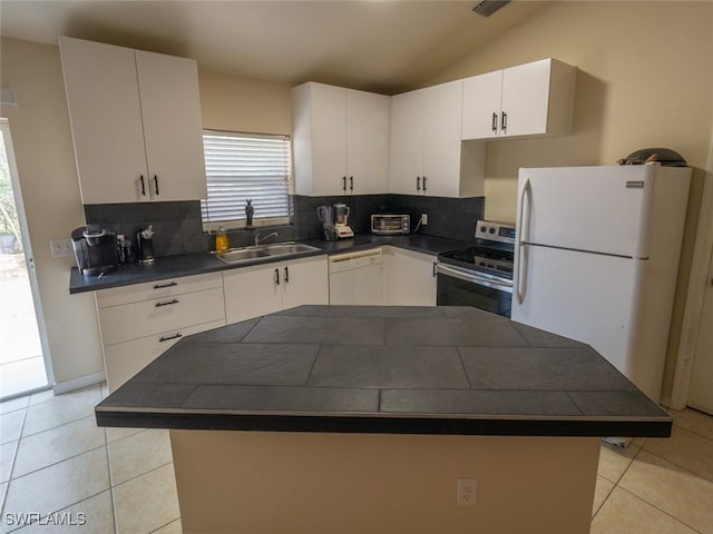 kitchen featuring backsplash, white appliances, sink, white cabinetry, and lofted ceiling