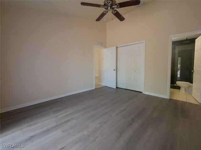 unfurnished bedroom featuring ceiling fan, a closet, ensuite bathroom, and light hardwood / wood-style flooring