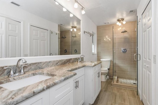 bathroom featuring vanity, toilet, and walk in shower