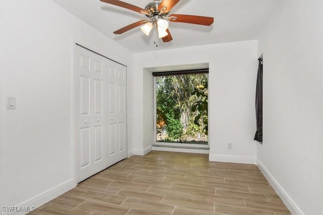 unfurnished bedroom with ceiling fan and a closet