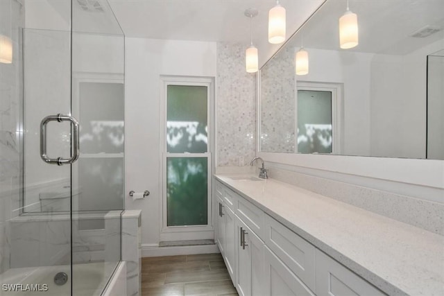 bathroom featuring shower / bath combination with glass door and vanity