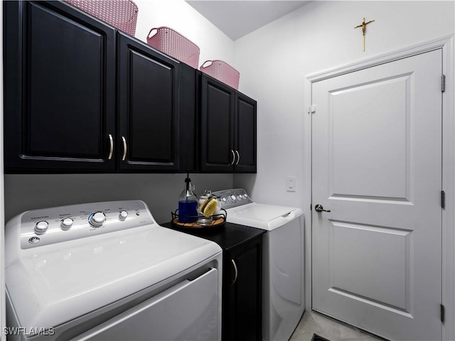 clothes washing area featuring washing machine and clothes dryer, light tile patterned flooring, and cabinets