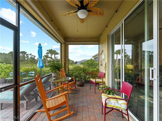 sunroom / solarium featuring ceiling fan