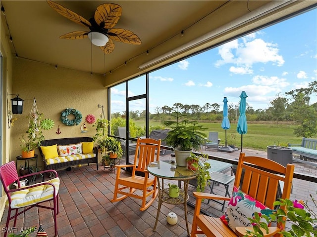 sunroom featuring ceiling fan