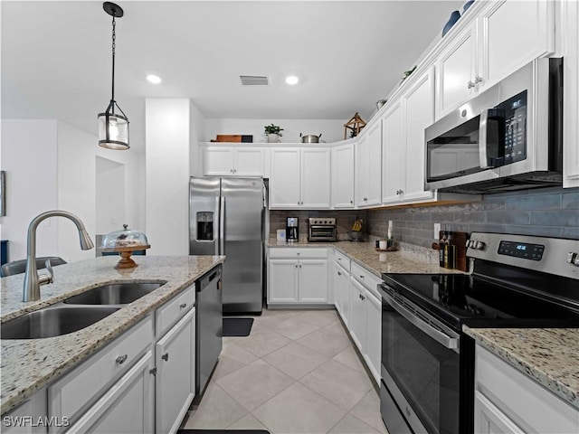 kitchen featuring sink, white cabinets, hanging light fixtures, and appliances with stainless steel finishes