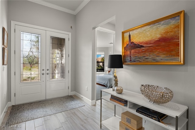 foyer entrance with crown molding and french doors