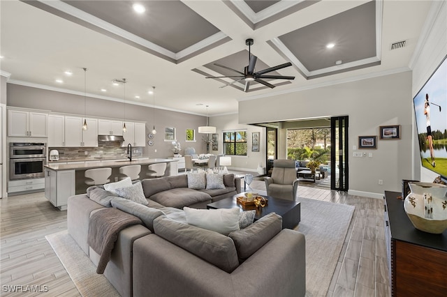 living room featuring ceiling fan, coffered ceiling, beamed ceiling, light hardwood / wood-style floors, and ornamental molding