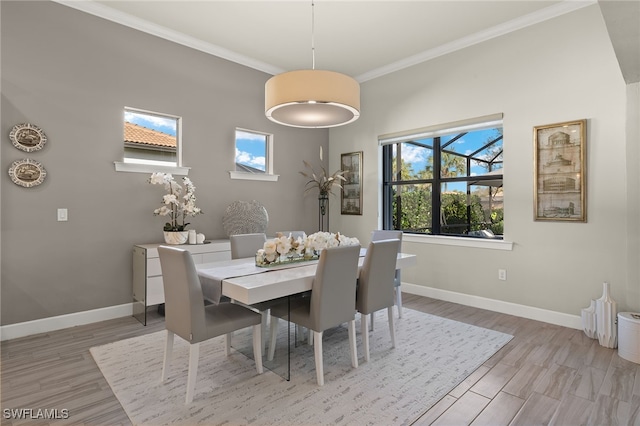 dining room with crown molding and light hardwood / wood-style flooring