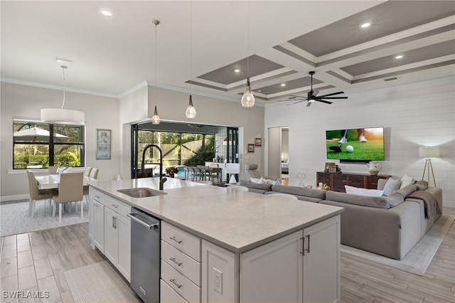 kitchen with coffered ceiling, a kitchen island with sink, ceiling fan, white cabinetry, and hanging light fixtures