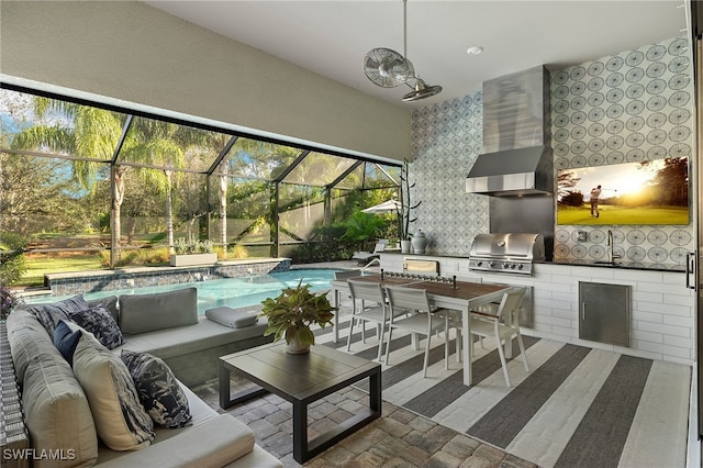 view of patio / terrace with a lanai, a grill, an outdoor living space, and an outdoor kitchen