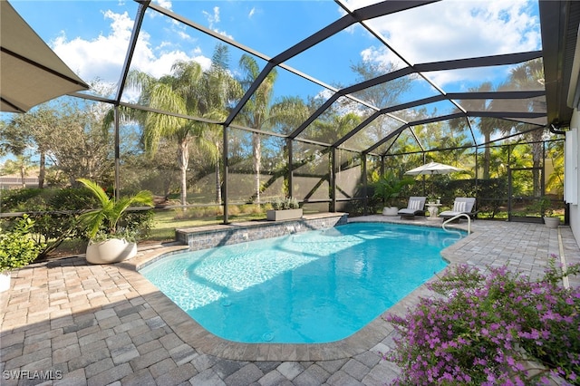 view of pool featuring glass enclosure and a patio