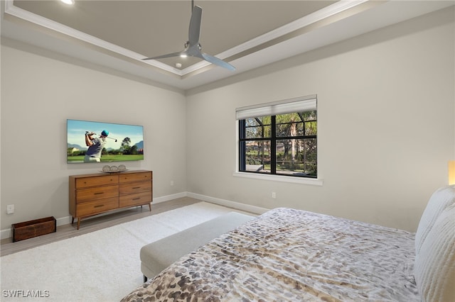 bedroom featuring ceiling fan, crown molding, and a tray ceiling