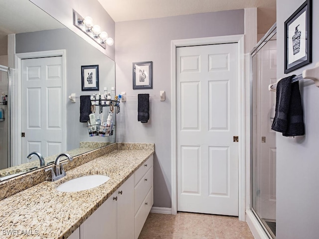 bathroom featuring vanity, a shower with door, and tile patterned flooring