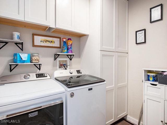 clothes washing area with cabinets and washer and dryer