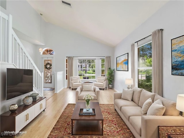 living room featuring light hardwood / wood-style floors and high vaulted ceiling