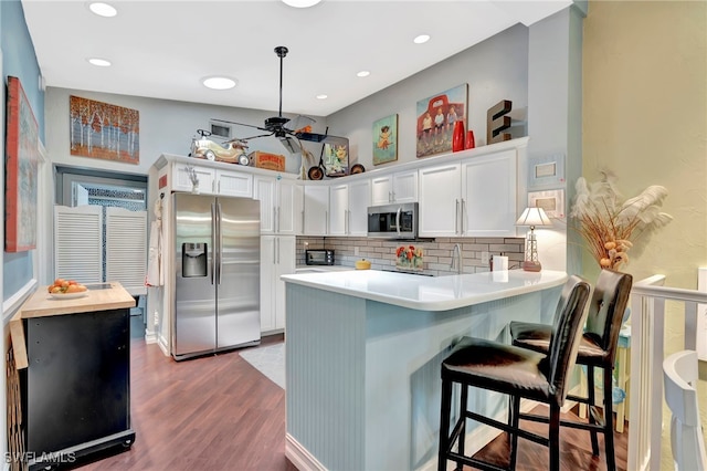 2511 Estey Ave Unit E4, Naples, FL 34104 - kitchen featuring appliances with stainless steel finishes, a peninsula, light countertops, wood finished floors, and ceiling fan