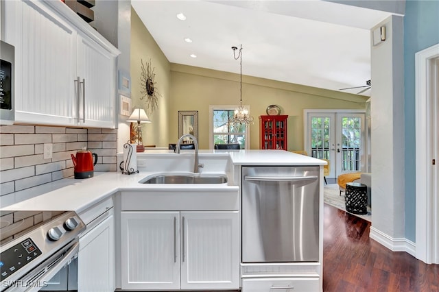 2511 Estey Ave Unit E4, Naples, FL 34104 - kitchen featuring appliances with stainless steel finishes, a peninsula, decorative backsplash, dark wood finished floors, and french doors