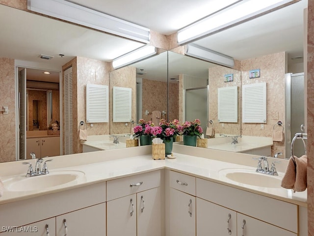 bathroom with a shower with door and vanity