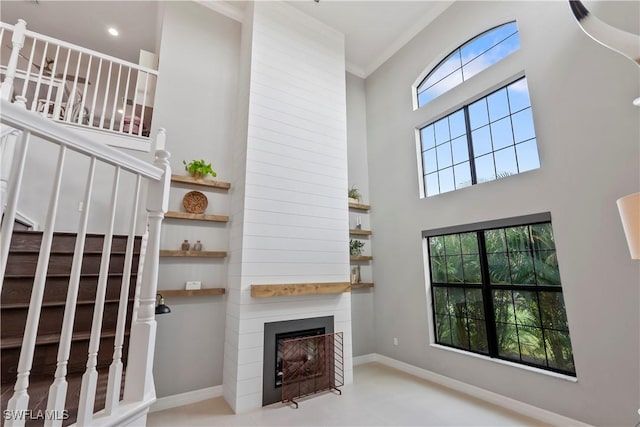 unfurnished living room with a large fireplace and ornamental molding