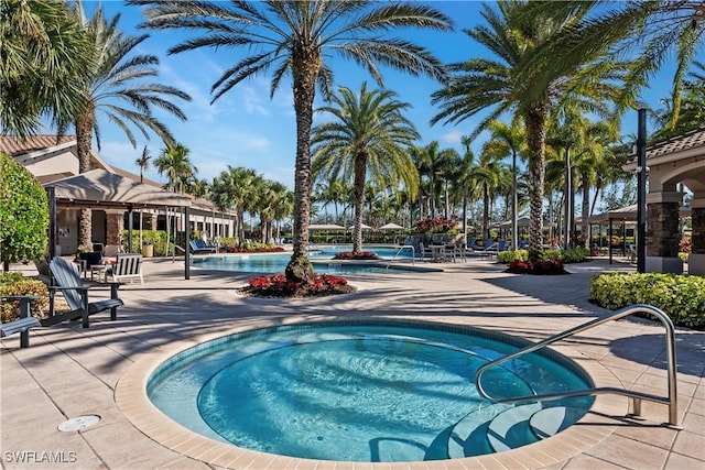 view of swimming pool with a hot tub