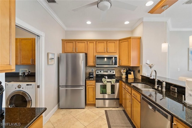 kitchen with pendant lighting, sink, light tile patterned floors, appliances with stainless steel finishes, and washer / dryer