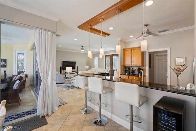 kitchen with pendant lighting, a breakfast bar, ceiling fan, and wine cooler