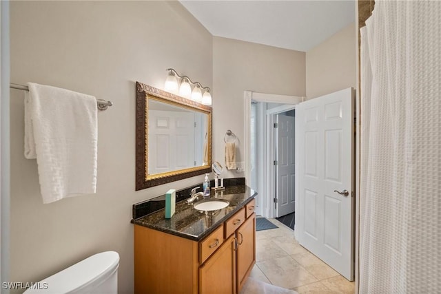 bathroom with tile patterned floors, vanity, toilet, and walk in shower