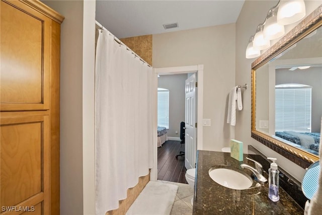 bathroom featuring tile patterned flooring, vanity, and toilet