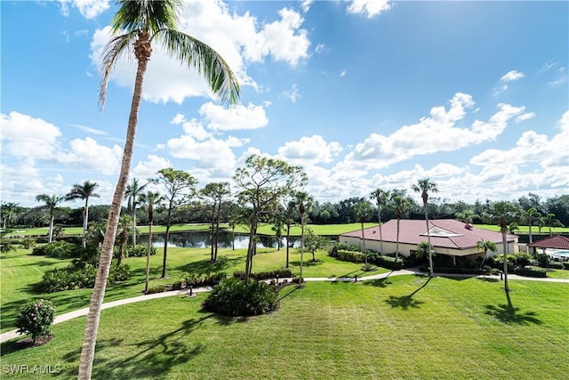 view of property's community with a lawn and a water view