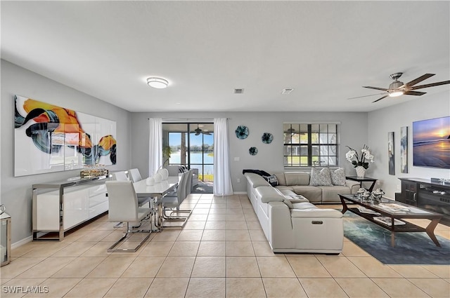 living room featuring ceiling fan, a wealth of natural light, and light tile patterned flooring