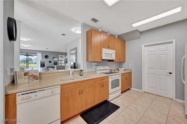 kitchen featuring sink, light tile patterned flooring, and white appliances