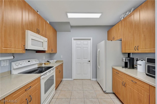 kitchen featuring light tile patterned floors and white appliances